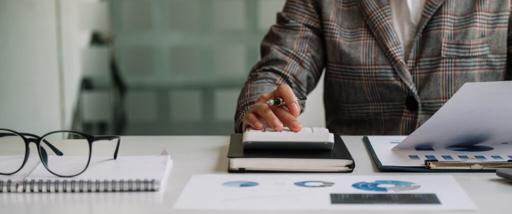 Close up view of bookkeeper or financial inspector hands making report, calculating or checking